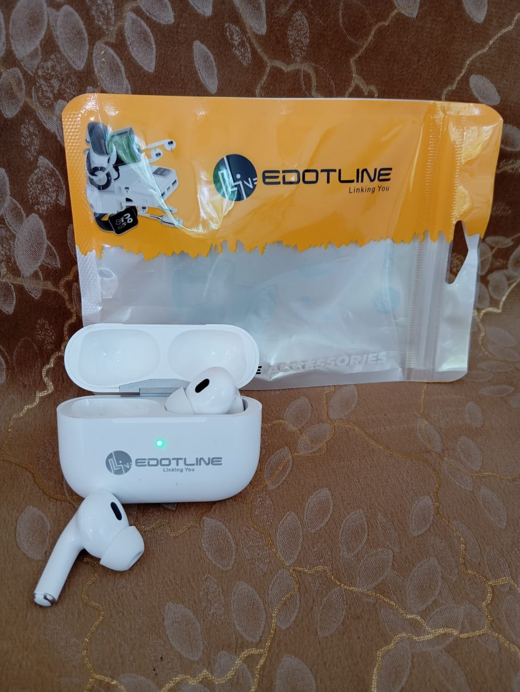Edotline Pro 2 earbuds with open case and orange packaging on fabric background