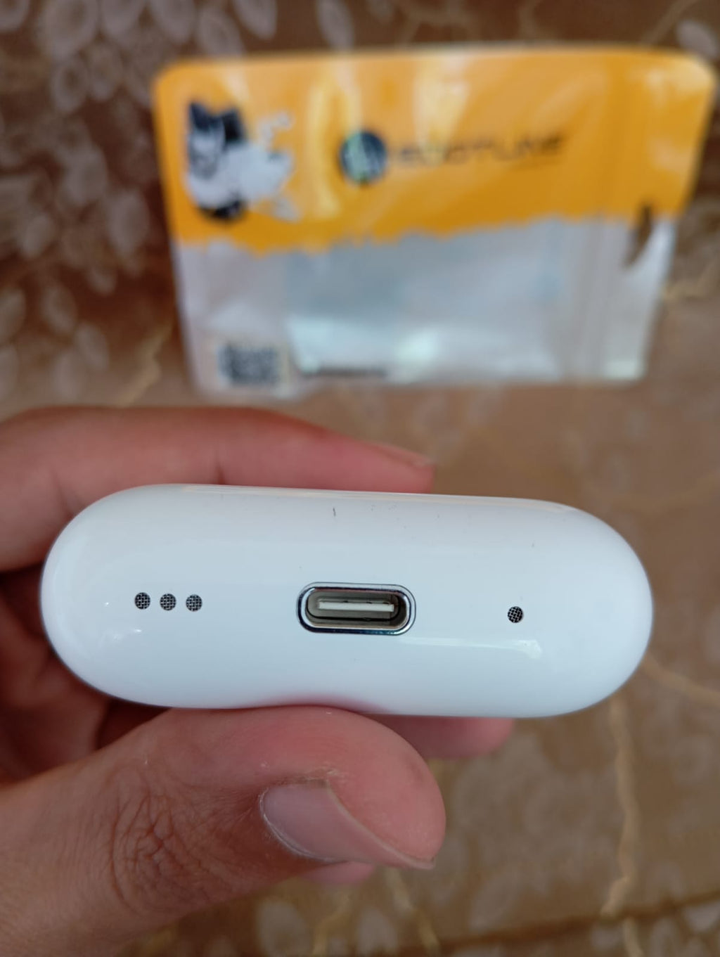 Edotline Pro 2 charging case bottom showing Type-C port held in hand