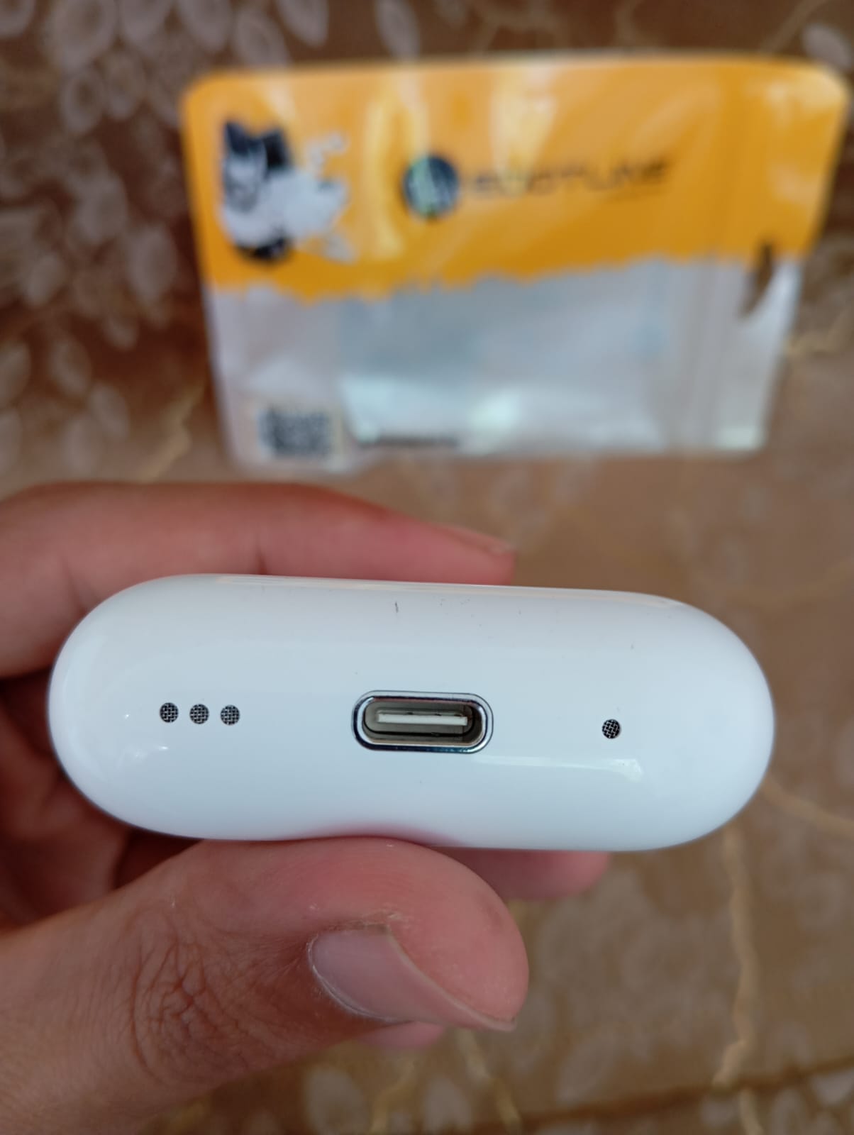 Edotline Pro 2 charging case bottom showing Type-C port held in hand