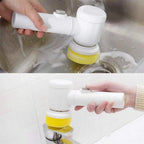 Electric scrubber with sponge attachment cleaning a sink and tap