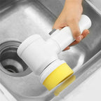 Cordless electric cleaning brush with yellow sponge head in a sink
