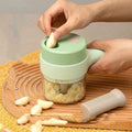 Garlic being added through the top opening of an electric chopper